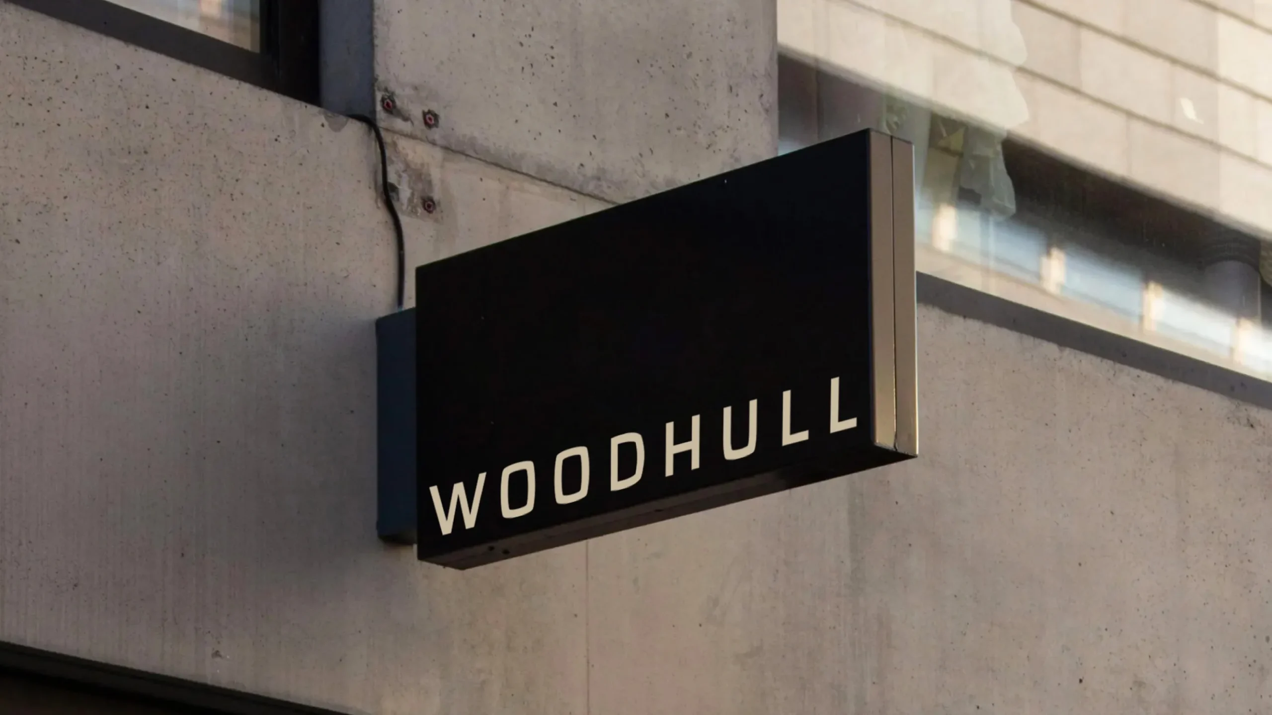 Minimalist Woodhull sign on a building exterior, reflecting expertise in architecture branding