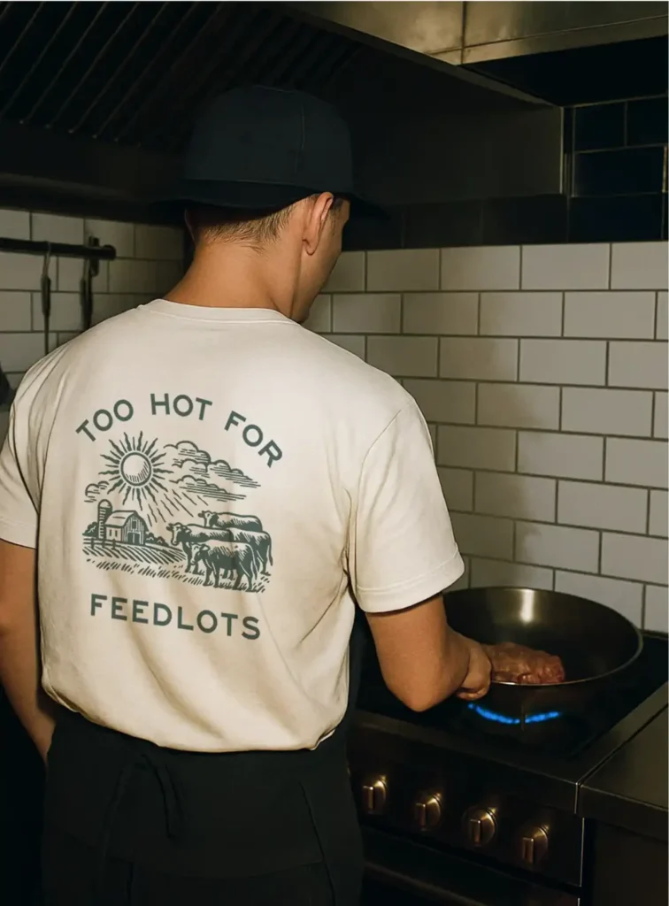 DTC marketing campaign photo of man cooking in Walden Local tee on high-end stove.