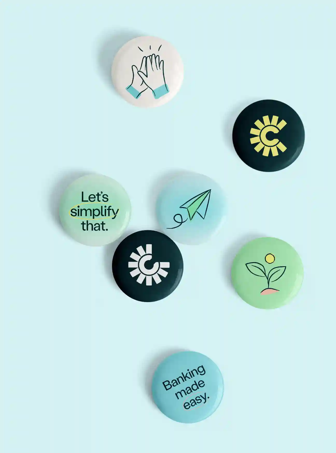 Seven colorful pins on a light blue background, featuring bank logos, uplifting phrases, and simple line illustrations like a paper airplane, plant, and hands high-fiving.